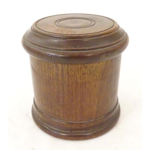 1163 - An early 20thC turned mahogany treen box and cover / container of cylindrical form with banded decor... 