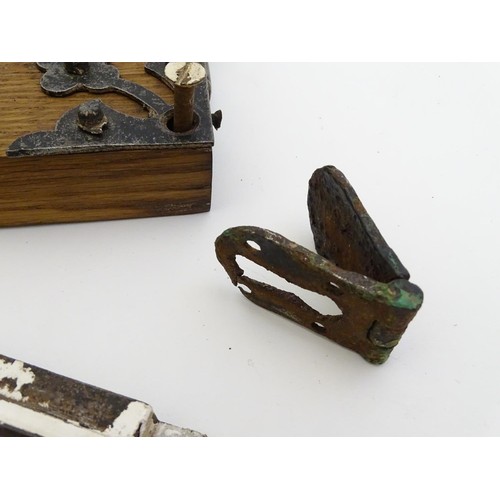 1253 - An 18thC door lock mechanism and key, with fittings, mounted to an oak panel with trefoil decoration... 