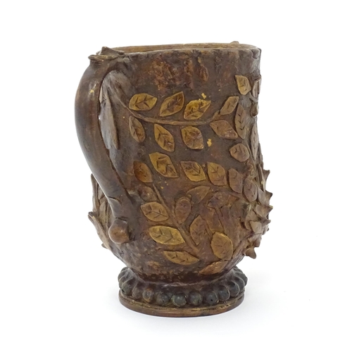 1260 - An Arts & Crafts leather and papier mache twin handled vase with wooden base and  foliate decoration... 