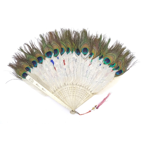 1299 - Two early 20thC fans, one bone with peacock feather detail, the other ebonised with needlework and p... 