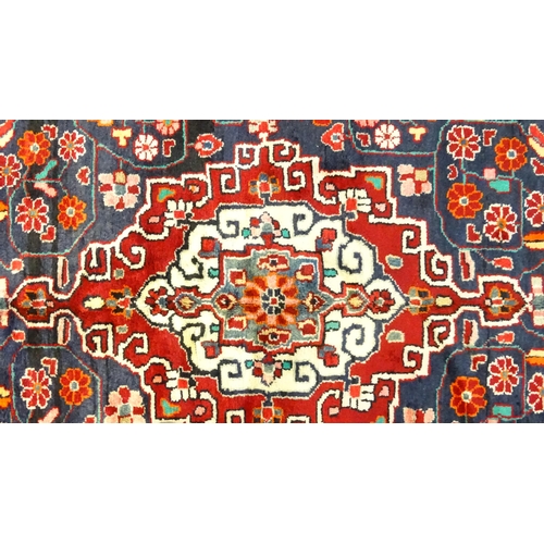 1500 - Carpet / Rug :  A Central Persian Sarouk rug  having a red, blue and cream ground with geometric flo... 