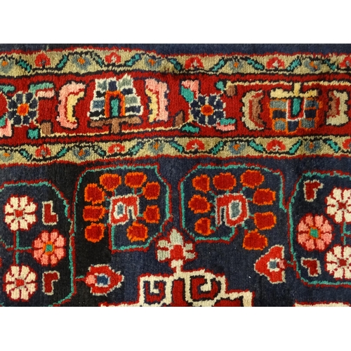 1500 - Carpet / Rug :  A Central Persian Sarouk rug  having a red, blue and cream ground with geometric flo... 