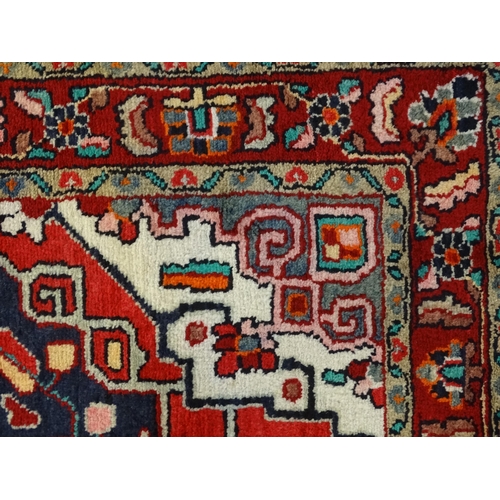 1500 - Carpet / Rug :  A Central Persian Sarouk rug  having a red, blue and cream ground with geometric flo... 