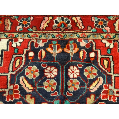 1500 - Carpet / Rug :  A Central Persian Sarouk rug  having a red, blue and cream ground with geometric flo... 