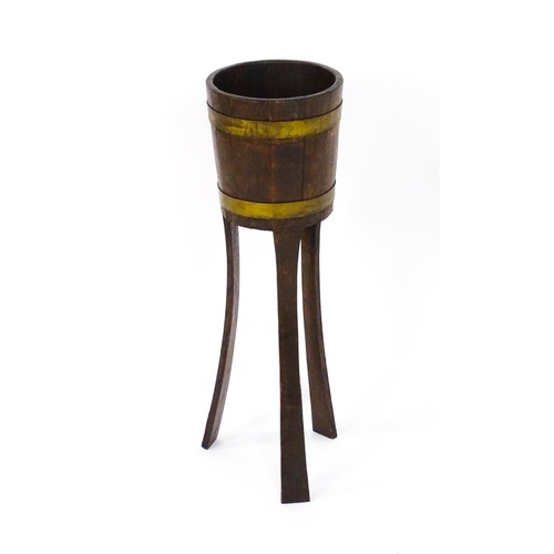 1616 - A late 19thC / early 20thC oak jardinière with a coopered barrel top with brass banding and raised o... 