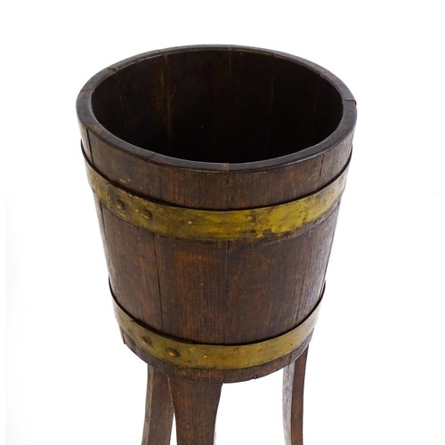 1616 - A late 19thC / early 20thC oak jardinière with a coopered barrel top with brass banding and raised o... 