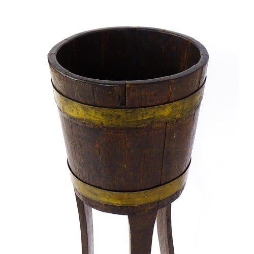 1616 - A late 19thC / early 20thC oak jardinière with a coopered barrel top with brass banding and raised o... 