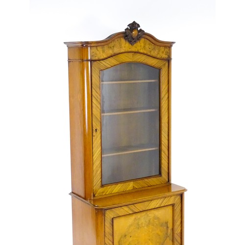 1624 - An early 20thC walnut bookcase with a carved pediment above a moulded cornice and single glazed door... 