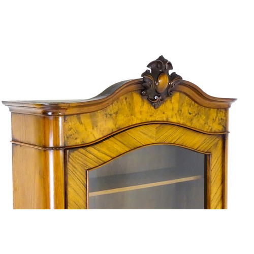 1624 - An early 20thC walnut bookcase with a carved pediment above a moulded cornice and single glazed door... 