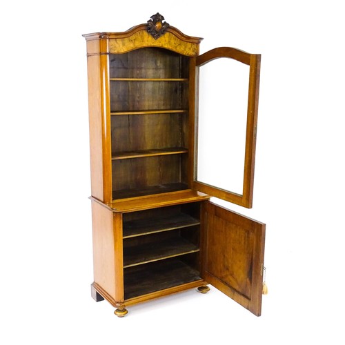 1624 - An early 20thC walnut bookcase with a carved pediment above a moulded cornice and single glazed door... 