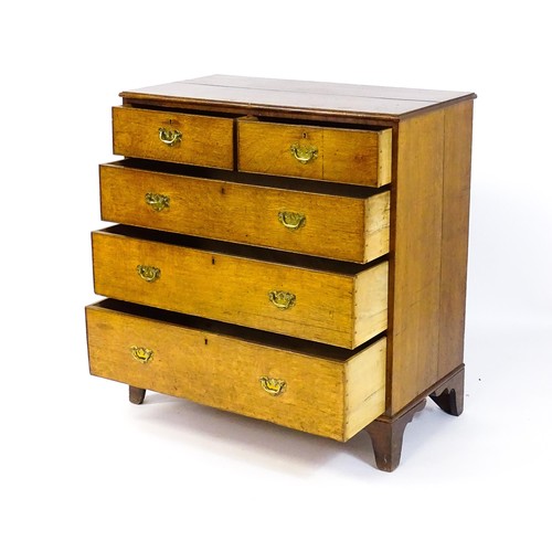 1625 - A late Georgian oak chest of drawers with a moulded top above two short over three long drawers with... 