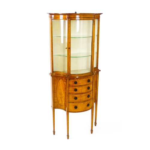 1629 - A 20thC display cabinet in the Sheraton style, having satinwood veneers over a serpentine shaped str... 