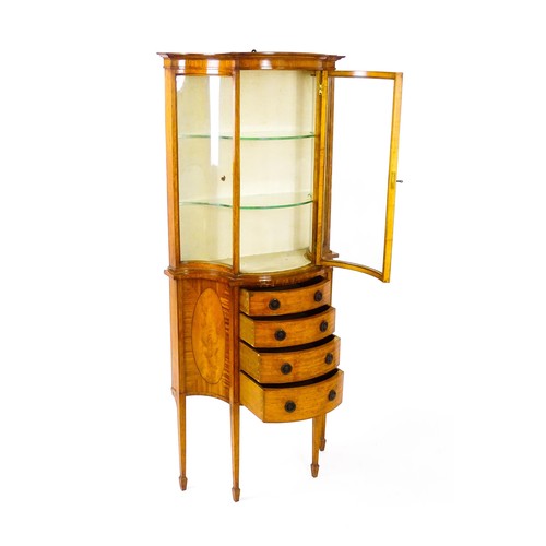 1629 - A 20thC display cabinet in the Sheraton style, having satinwood veneers over a serpentine shaped str... 