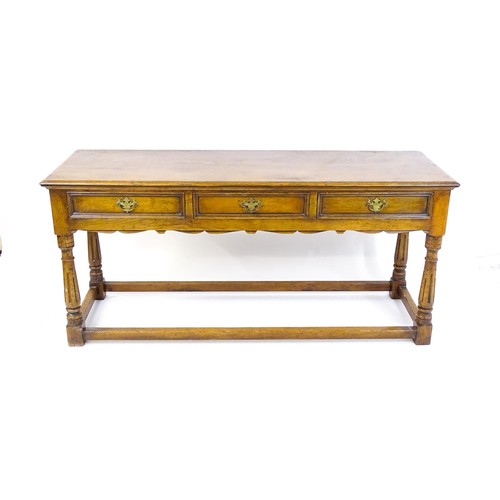 1644 - A mid 20thC oak dresser base with a moulded rectangular top above three short drawers with brass han... 