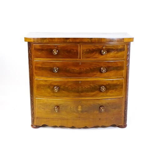 1653 - A Victorian bow fronted chest of drawers, comprising two short over three long drawers with turned w... 