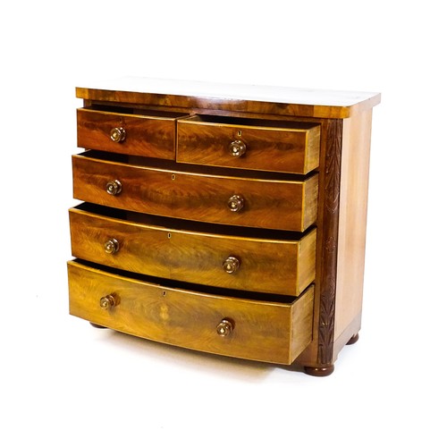 1653 - A Victorian bow fronted chest of drawers, comprising two short over three long drawers with turned w... 