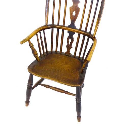 1668 - A mid 19thC ash and elm double bow back Windsor armchair, having a central pierced back splat above ... 