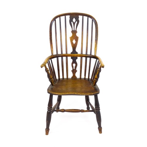 1668 - A mid 19thC ash and elm double bow back Windsor armchair, having a central pierced back splat above ... 