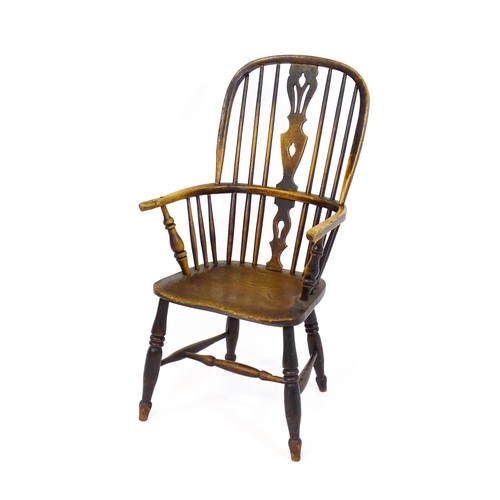 1668 - A mid 19thC ash and elm double bow back Windsor armchair, having a central pierced back splat above ... 