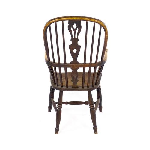 1668 - A mid 19thC ash and elm double bow back Windsor armchair, having a central pierced back splat above ... 