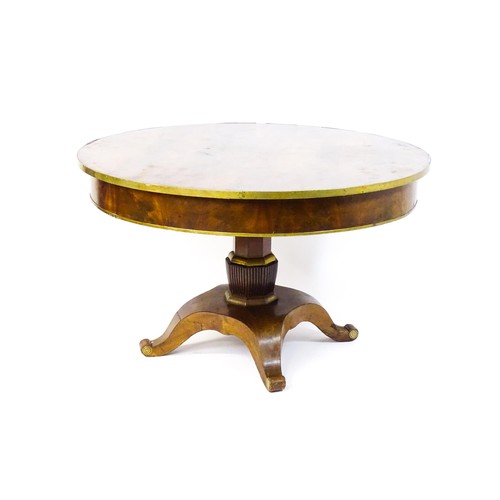 1671 - A 19thC mahogany breakfast table with a circular top and brass rim, the table having a canted pedest... 