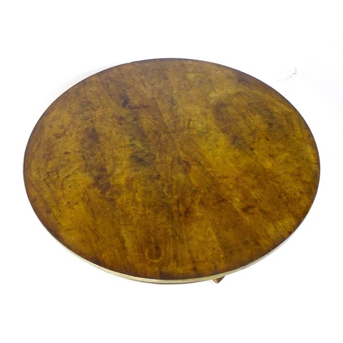 1671 - A 19thC mahogany breakfast table with a circular top and brass rim, the table having a canted pedest... 