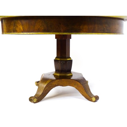 1671 - A 19thC mahogany breakfast table with a circular top and brass rim, the table having a canted pedest... 