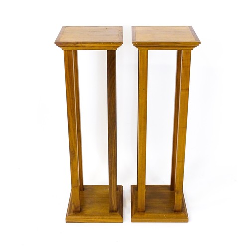 1672 - A pair of late 20thC / early 21stC walnut jardinière stands / pedestals, with square tops raised on ... 