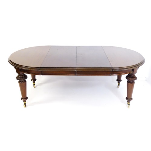 1677 - A Victorian mahogany dining table of circular form, extending to form an oval, the table raised on f... 