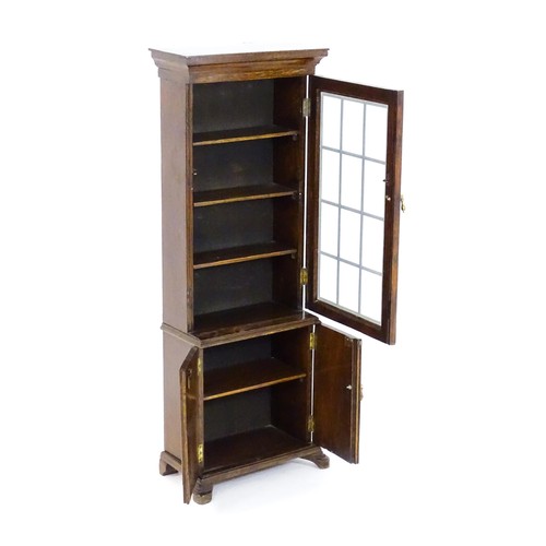 1681 - A 20thC oak cabinet of small proportions, with a moulded cornice above a glazed door and cupboard be... 