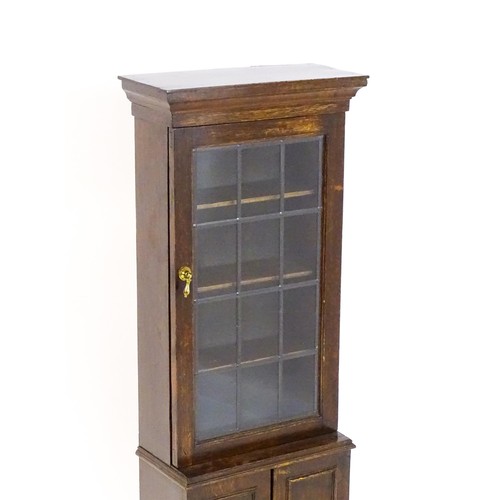 1681 - A 20thC oak cabinet of small proportions, with a moulded cornice above a glazed door and cupboard be... 