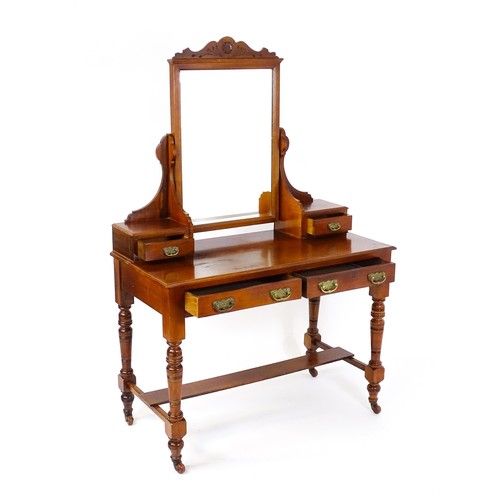 1689 - An Aesthetic movement mahogany dressing table with carved floral detailing, two short drawers above ... 