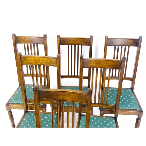 1691 - A set of six early / mid 20thC oak dining chairs, with slatted back splats, drop in seats and raised... 