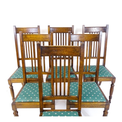 1691 - A set of six early / mid 20thC oak dining chairs, with slatted back splats, drop in seats and raised... 