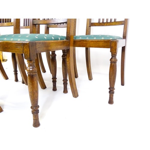 1691 - A set of six early / mid 20thC oak dining chairs, with slatted back splats, drop in seats and raised... 