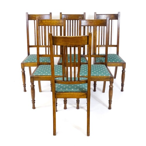 1691 - A set of six early / mid 20thC oak dining chairs, with slatted back splats, drop in seats and raised... 