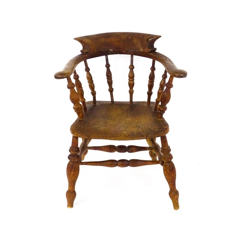 1693 - A late 19thC / early 20thC smokers bow chair, with a bowed backrest, turned tapering supports and a ... 