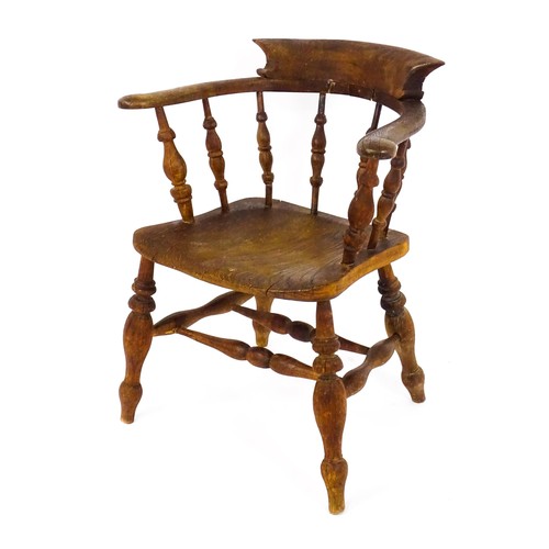 1693 - A late 19thC / early 20thC smokers bow chair, with a bowed backrest, turned tapering supports and a ... 