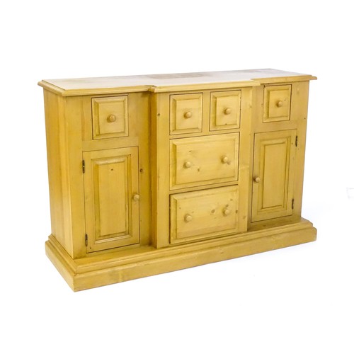 1700 - A modern pine sideboard with a moulded breakfront top, five short drawers and two panelled cupboards... 