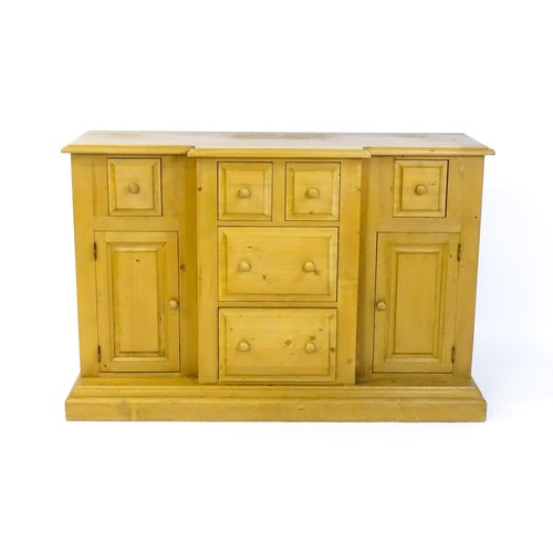 1700 - A modern pine sideboard with a moulded breakfront top, five short drawers and two panelled cupboards... 