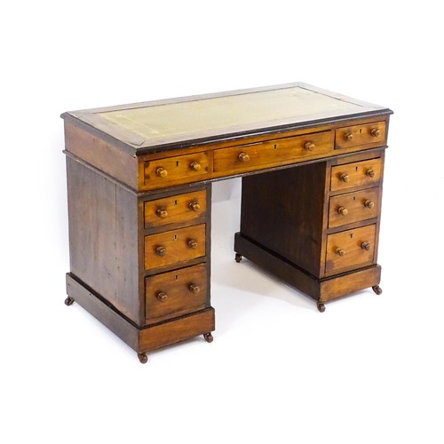 1703 - A late 19thC / early 20thC double pedestal desk with an inset leather top and two banks of four shor... 