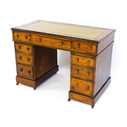 1703 - A late 19thC / early 20thC double pedestal desk with an inset leather top and two banks of four shor... 