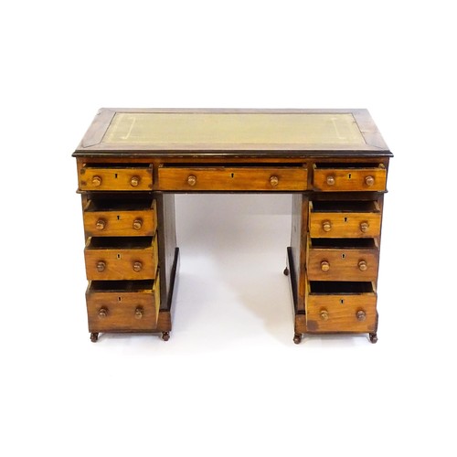 1703 - A late 19thC / early 20thC double pedestal desk with an inset leather top and two banks of four shor... 