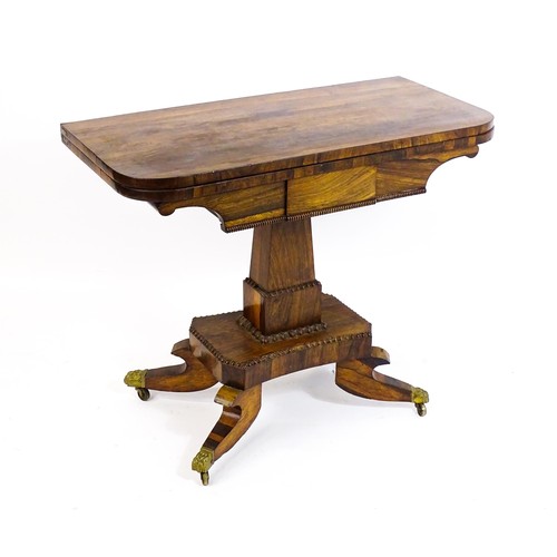 1704 - A 19thC rosewood card table, with a swivelling, folding table top above a tapering pedestal and a ba... 