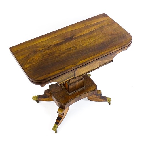 1704 - A 19thC rosewood card table, with a swivelling, folding table top above a tapering pedestal and a ba... 