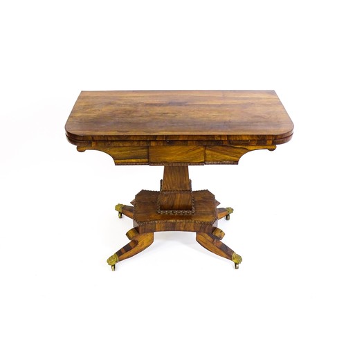 1704 - A 19thC rosewood card table, with a swivelling, folding table top above a tapering pedestal and a ba... 