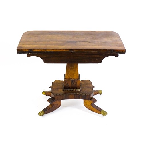 1704 - A 19thC rosewood card table, with a swivelling, folding table top above a tapering pedestal and a ba... 