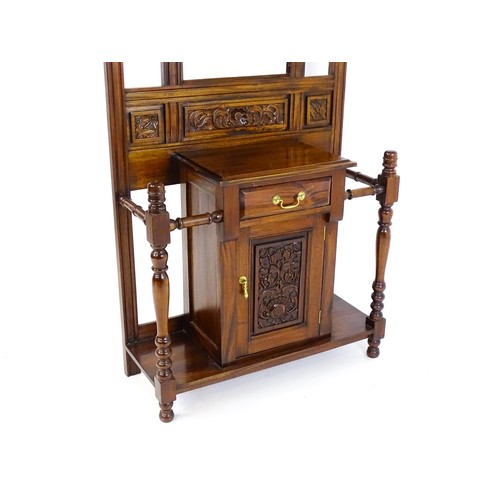 1709 - An Aesthetic style hall stand of mahogany construction, surmounted by turned finials and floral carv... 