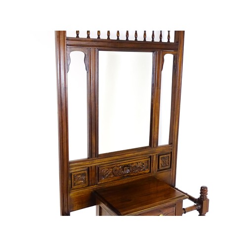 1709 - An Aesthetic style hall stand of mahogany construction, surmounted by turned finials and floral carv... 