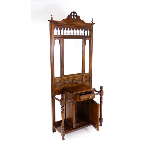 1709 - An Aesthetic style hall stand of mahogany construction, surmounted by turned finials and floral carv... 